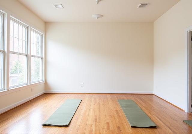 Main practice room at Veridian Stretch with natural light and wooden floors.